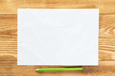Tahta masanın üzerinde duran bir kağıt parçası.