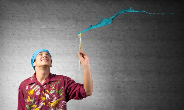 Genç sanatçı mavi fırça darbesi boyuyor — Stok fotoğraf