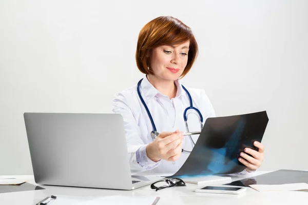 Hermoso médico mirando la radiografía en el consultorio —  Fotos de Stock