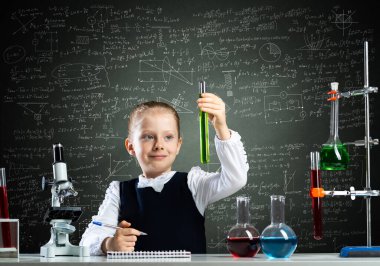 Küçük bilim kadını test tüpünü inceliyor.