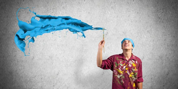 Ung konstnär måla blå pensel stroke — Stockfoto