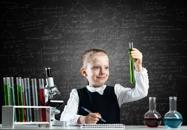 Klein meisje wetenschapper onderzoeken reageerbuis — Stockfoto