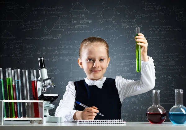 Klein meisje wetenschapper onderzoeken reageerbuis — Stockfoto