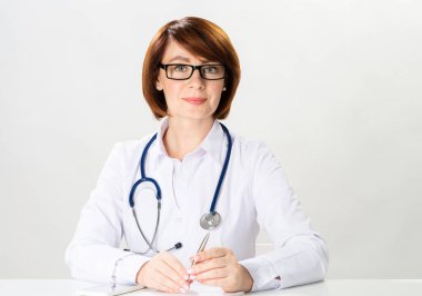 Ofiste oturan çekici kızıl saçlı doktor.