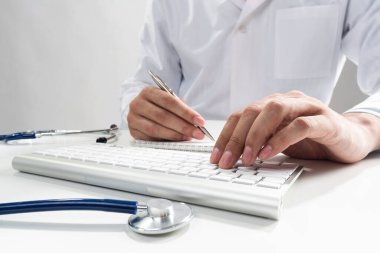 Kablosuz bilgisayar klavyesinde yazan doktor