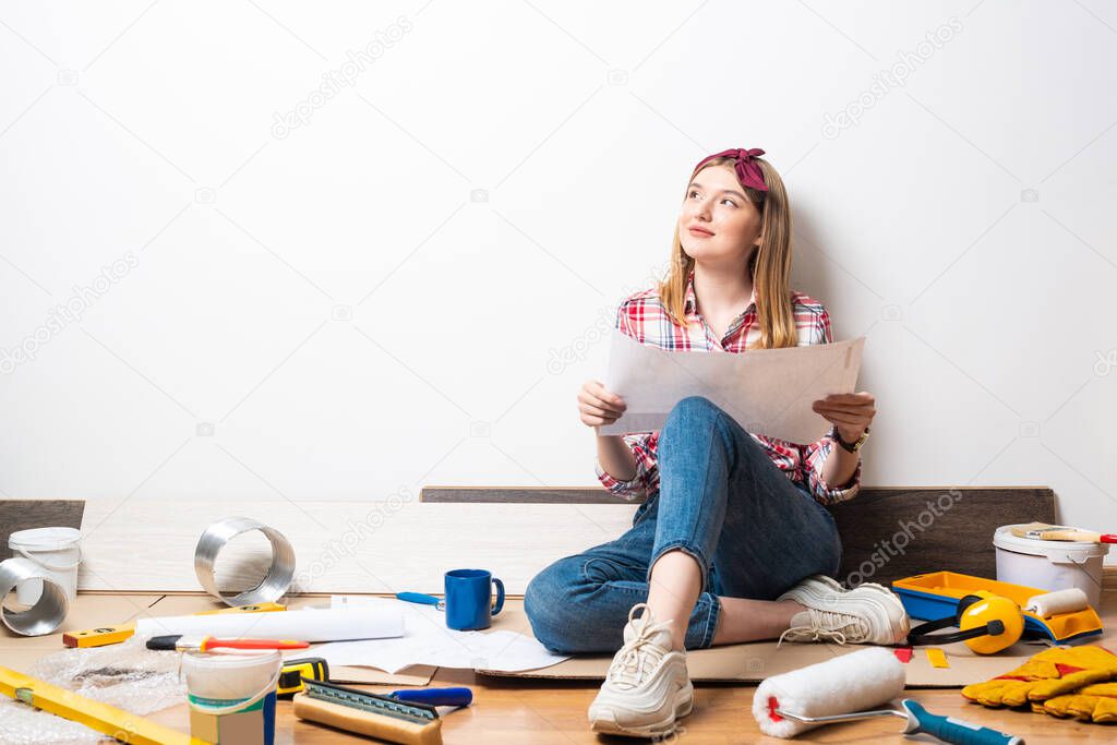 Beautiful woman sitting with paper blueprint