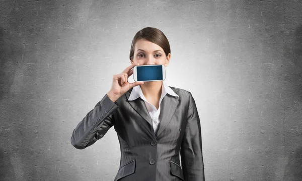 Woman covering her mouth with smartphone — Stock Photo, Image