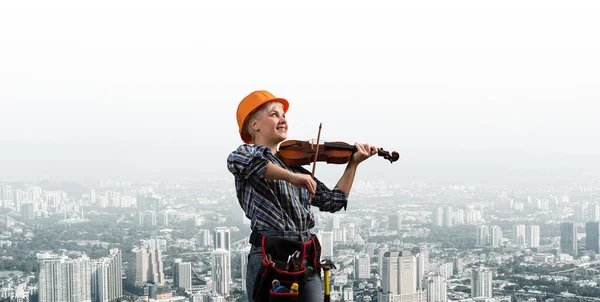 Mulher bonita no capacete de segurança tocando violino — Fotografia de Stock