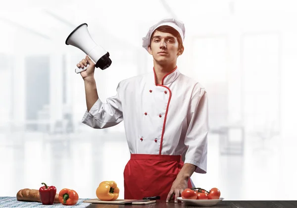 Jovem chef de pé com megafone na mão — Fotografia de Stock