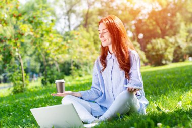 Genç kızıl saçlı kadın Lotus pozunda meditasyon yapıyor.