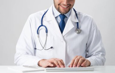 Kablosuz bilgisayar klavyesinde yazan erkek doktor