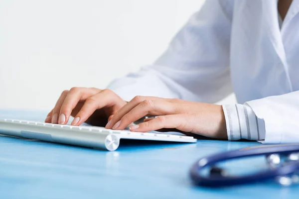 Doctor typing at computer keyboard