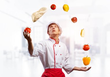 Genç aşçı yemek malzemeleriyle hokkabazlık yapıyor.