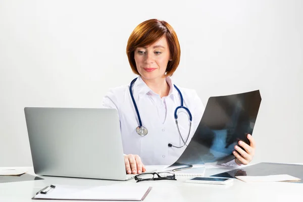 Hermoso médico mirando la radiografía en el consultorio —  Fotos de Stock