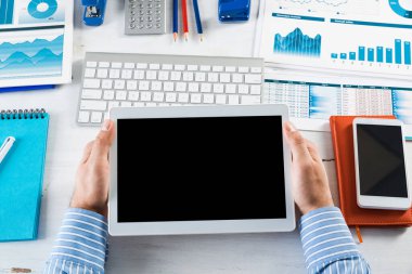 Tabletli bir işadamı, ofiste çalışıyor.