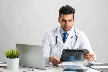 Yakışıklı genç doktor röntgen taramasına bakıyor.