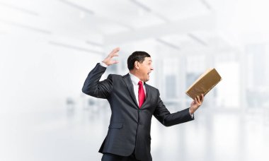 Açık bir kitap arayan etkileyici bir iş adamı.