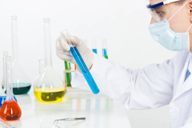 Güvenlik maskesi ve eldivenli laboratuvar teknisyeni.