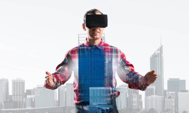 İşaretli gömlek ve sanal maske takan ellerini uzatıp konsantre olmaya çalışan bir adam.