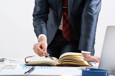 İşadamı masadaki mali belgeleri analiz ediyor.