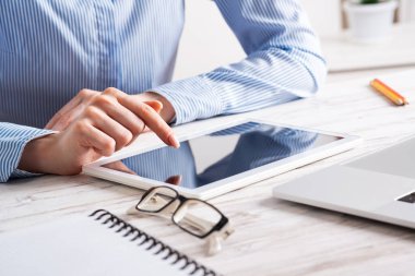 Masada tablet bilgisayar kullanan bir iş kadını.