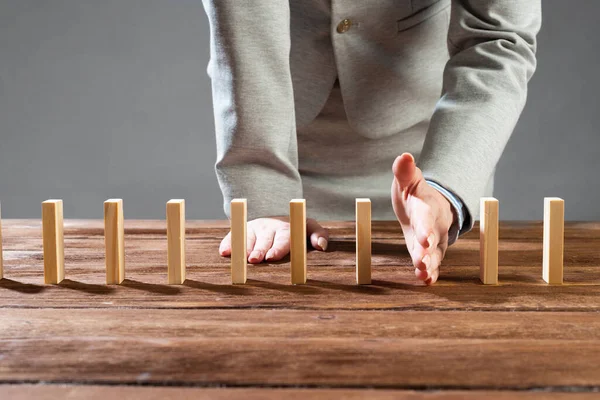 Business woman interrupting domino effect