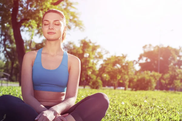 Kız nilüferde meditasyon yapıyor yeşil çimlerde poz veriyor. — Stok fotoğraf