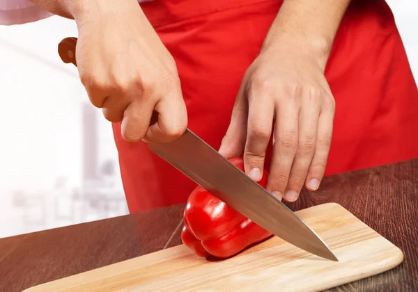Chef mãos cortando pimenta vermelha fresca — Fotografia de Stock