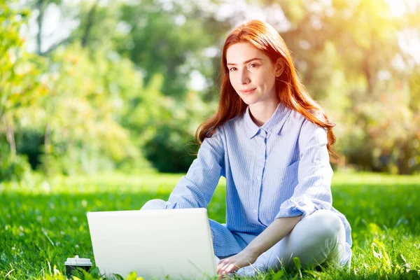 Junge rothaarige Frau benutzt Laptop — Stockfoto