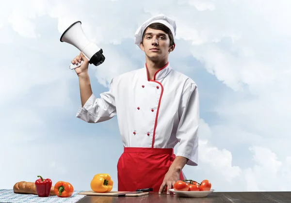 Jovem chef de pé com megafone na mão — Fotografia de Stock