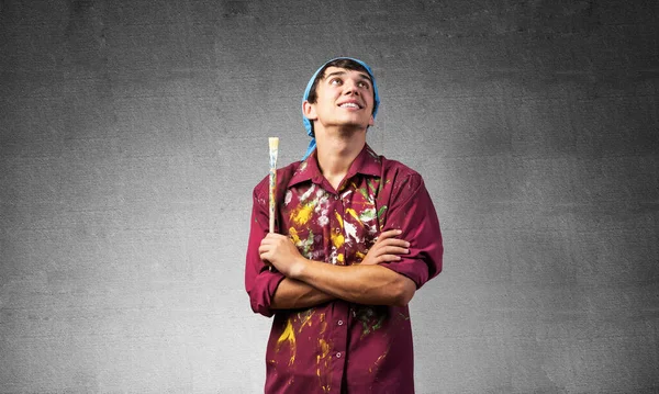 Smiling young painter artist holding paintbrush — Stock Photo, Image