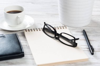 Beyaz kahve fincanıyla üst kattaki ofis masasında.