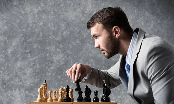Hombre de negocios moviendo figura de ajedrez en tablero de ajedrez —  Fotos de Stock