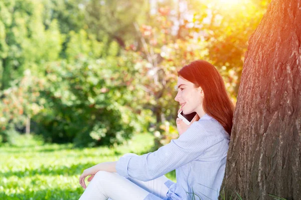 Młoda ruda kobieta mówi na smartfonie — Zdjęcie stockowe