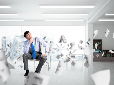 Genç işadamı bir ofis koltuğunda oturuyor.