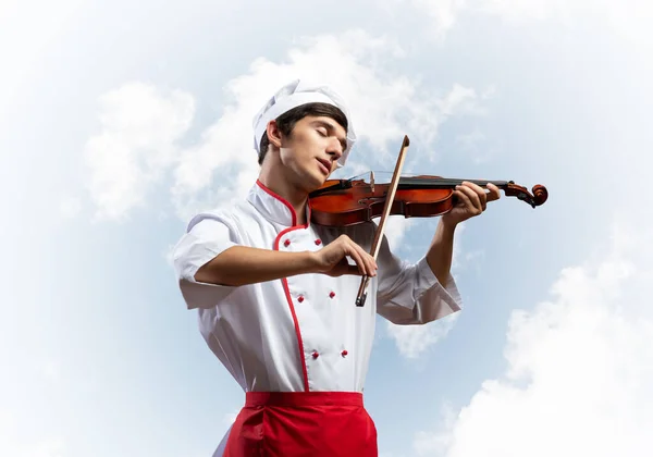 Jovem chef masculino tocando violino — Fotografia de Stock