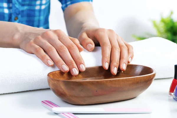 Closeup female hands in wooden bowl with water — Stock Photo, Image