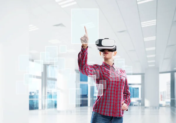 Flicka tittar med VR-enhet på panelen och arbetar på det. Blandade medier — Stockfoto