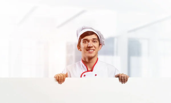 Молодой шеф-повар с белой вывеской — стоковое фото