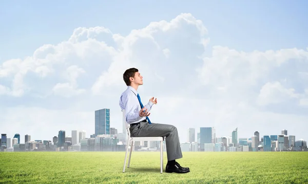 Businessman meditates on office chair — Stock Photo, Image