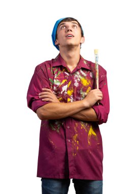 Gülümseyen genç ressam elinde fırça tutuyor.