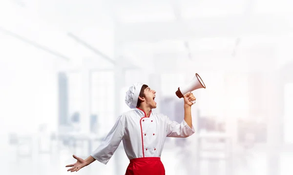 Молодой шеф-повар громко кричит в мегафон — стоковое фото
