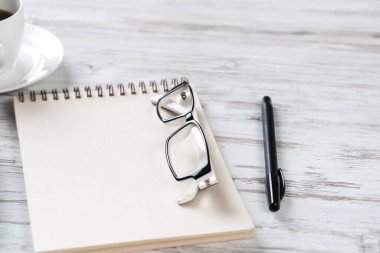 Beyaz kahve fincanıyla üst kattaki ofis masasında.