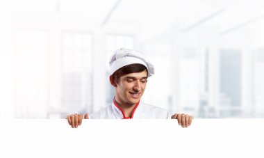 Beyaz tabelası olan genç bir aşçı.
