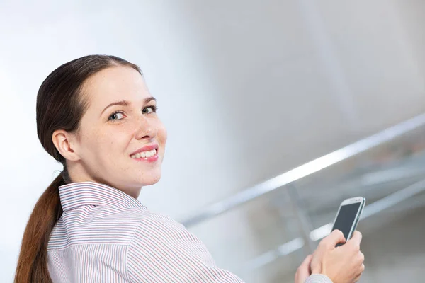 Ung attraktiv kvinna med telefon i händerna — Stockfoto