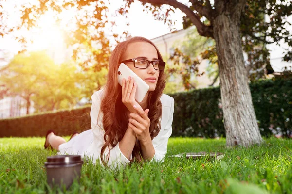 Mulher no parque com telefone — Fotografia de Stock