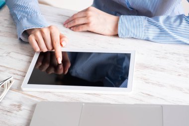 Masada tablet bilgisayar kullanan bir iş kadını.