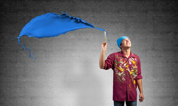 Young artist painting blue brush stroke — Stock Photo, Image