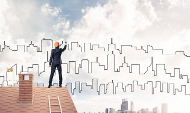 Erkek mimar mavi gökyüzüne modern şehrin siluetini çizer. Karışık