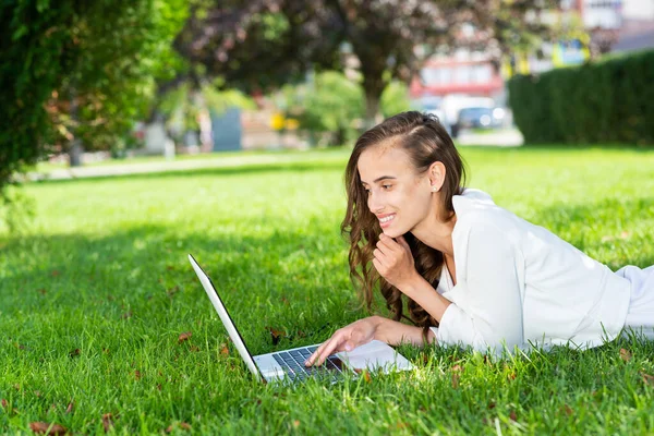 Jonge vrouw en laptop in het park — Stockfoto